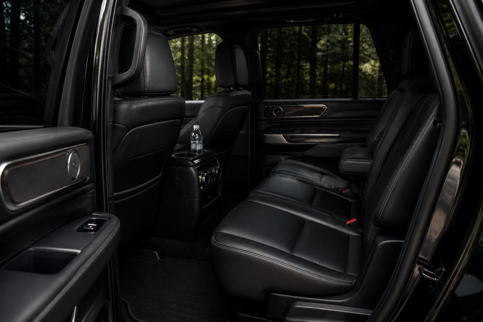 The spacious black leather rear passenger cabin of a luxury SUV.